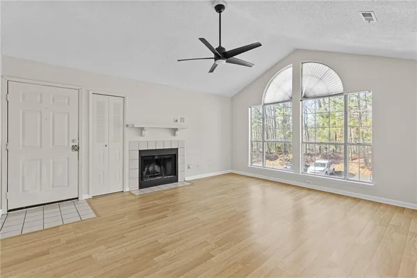 a view of an empty room with a fireplace and a window