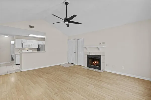 a view of an empty room with a fireplace and a window