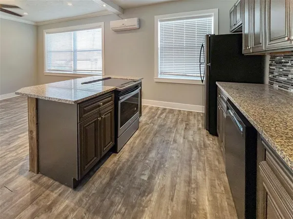 a kitchen with granite countertop a stove a sink and a refrigerator