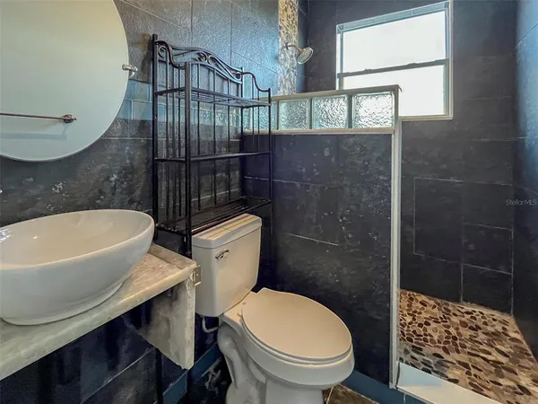 a bathroom with a toilet a sink and mirror