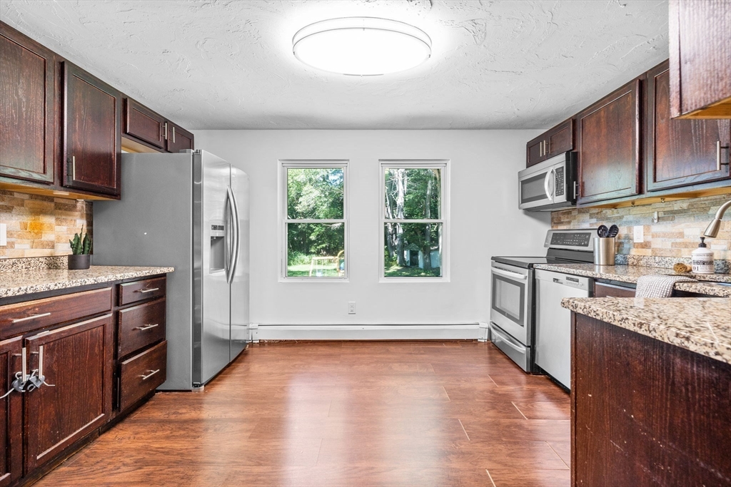 18 Pullard Road Grafton, MA 01519 - Photo 7 of 28 a kitchen with stainless steel appliances granite countertop a stove a sink dishwasher a refrigerator and cabinets with wooden floor