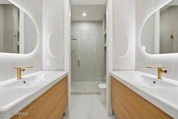 a bathroom with a sink a toilet and shower