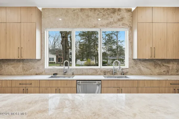 a kitchen with stainless steel appliances granite countertop a sink a granite counter tops and a large window