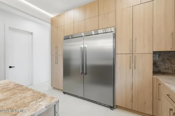 a bathroom with a granite countertop window and a refrigerator