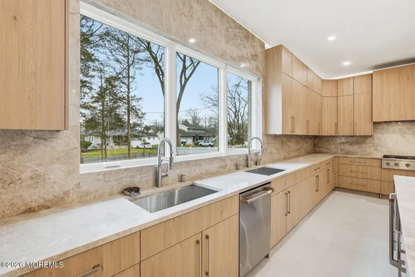 a kitchen with a sink window and cabinets