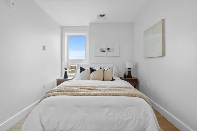 a bedroom with a bed and painting on the wall
