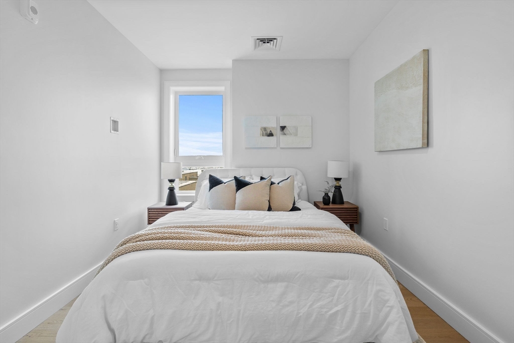 301 Border Street, Unit 409 Boston, MA 02128 - Photo 11 of 23 a bedroom with a bed and painting on the wall