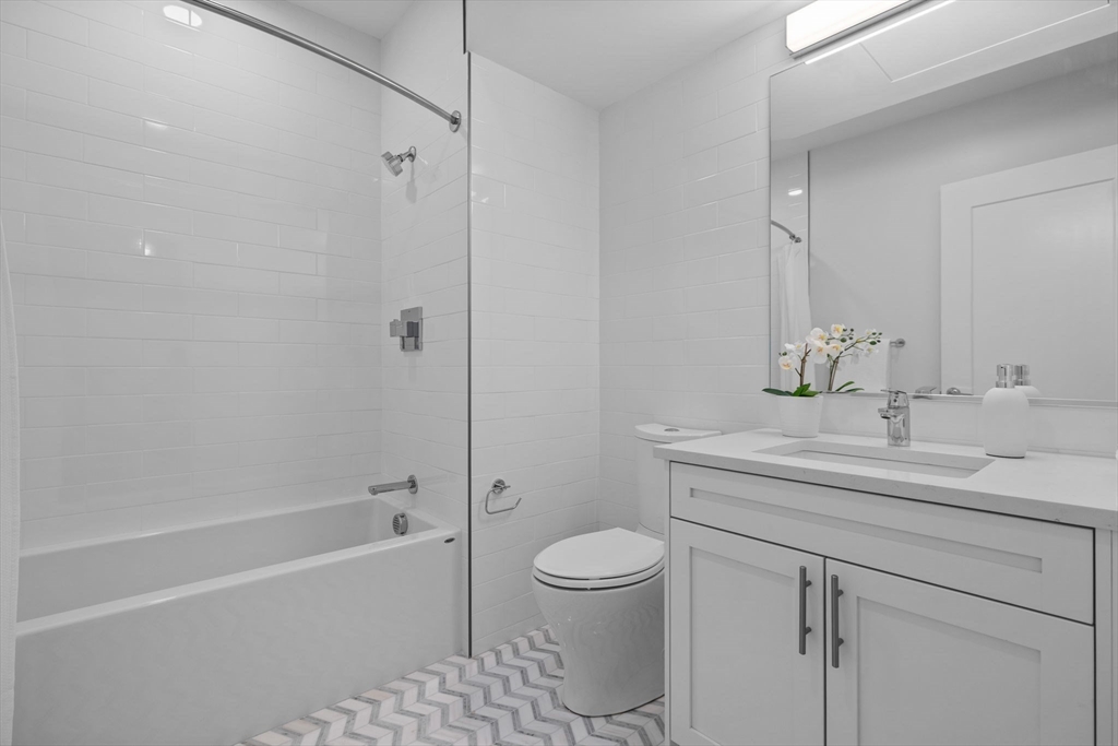 301 Border Street, Unit 409 Boston, MA 02128 - Photo 17 of 23 a bathroom with a sink a toilet and shower