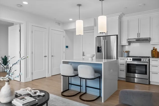 a kitchen with stainless steel appliances granite countertop a stove a refrigerator and a wooden floor