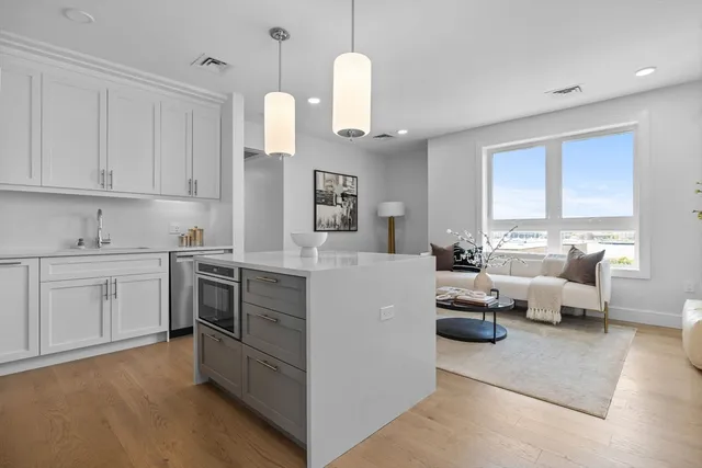 a kitchen with kitchen island white cabinets and white appliances