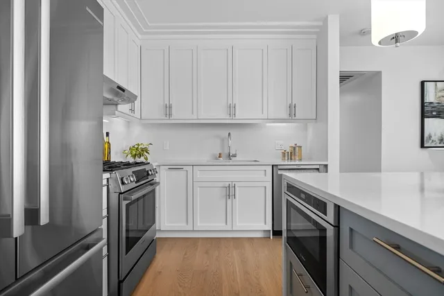 a kitchen with cabinets stainless steel appliances and a counter space