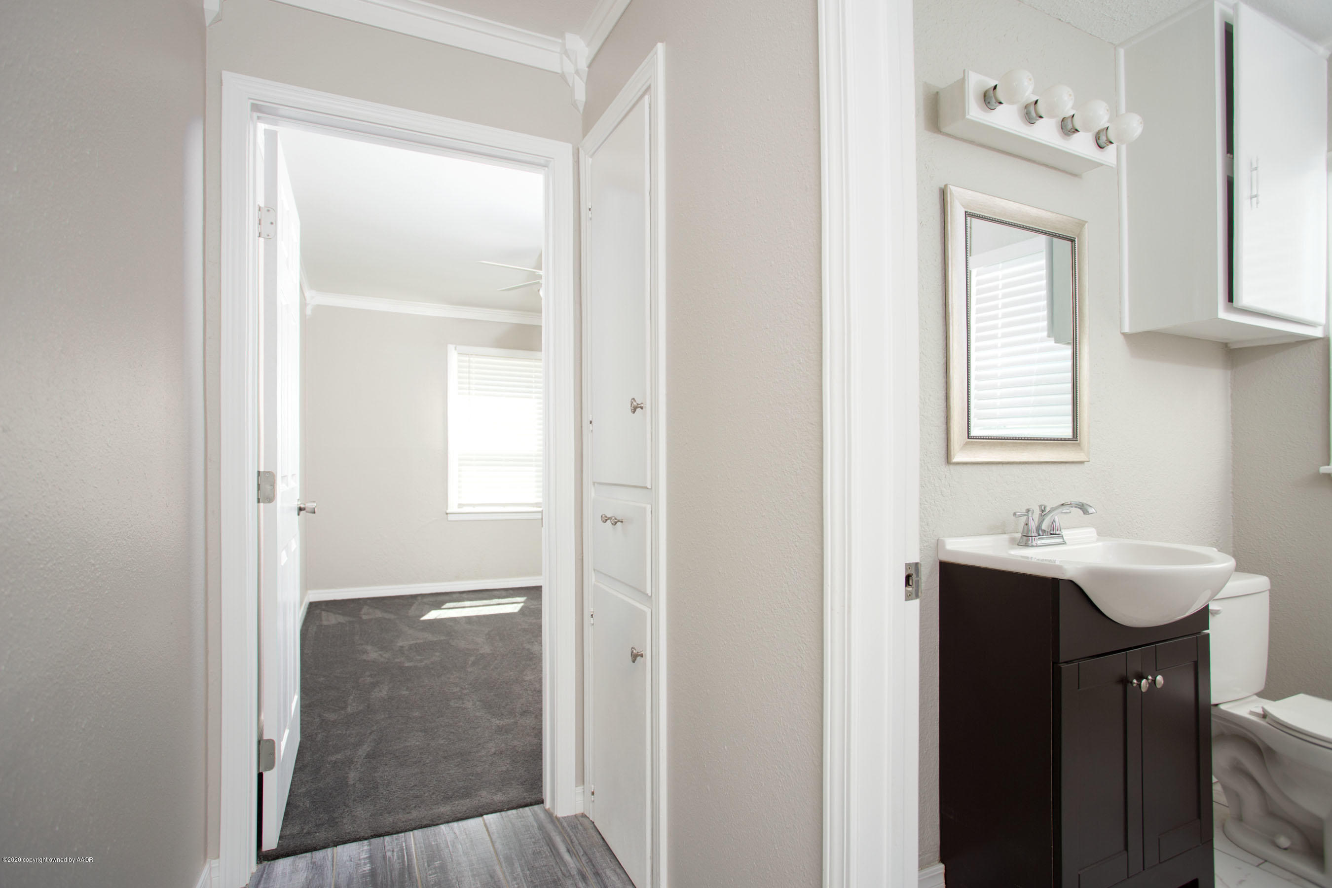 3616 Cline Road Amarillo, TX 79110 - Photo 13 of 29 a bathroom with a sink a mirror and a window