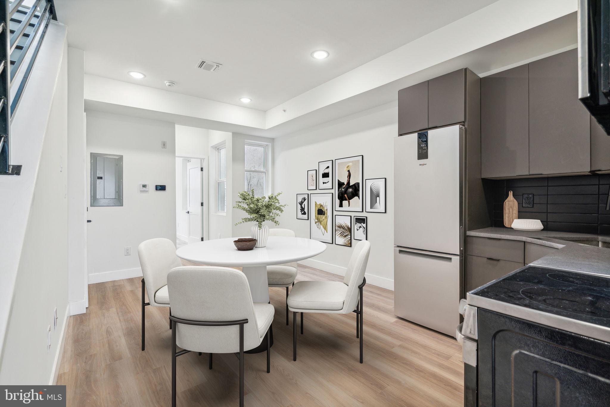 a kitchen with stainless steel appliances a dining table chairs and a refrigerator