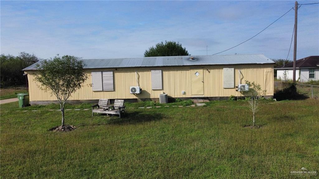 22946 North Kansas City Road Santa Rosa, TX 78593 - Photo 1 of 1 Back of house with a yard and central air condition unit