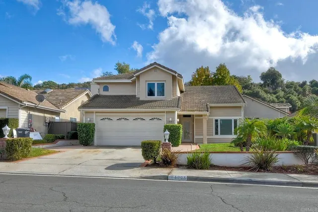 a front view of a house with a garden and a garage