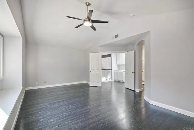 a view of empty room with wooden floor and window