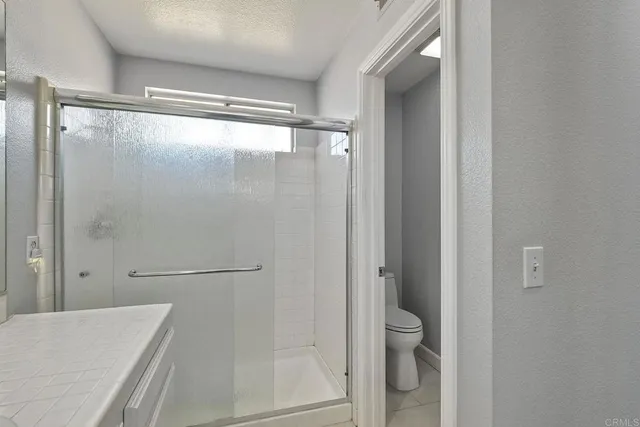 a bathroom with a granite countertop shower and a sink