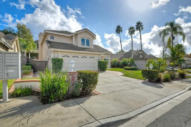 a front view of a house with a yard and a garden