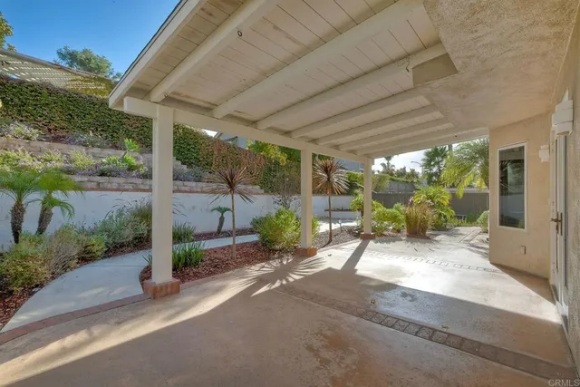 a view of a patio with table and chairs potted plants with floor to ceiling window