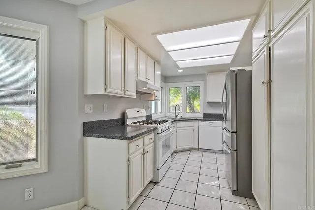 a kitchen with stainless steel appliances granite countertop a refrigerator and a sink