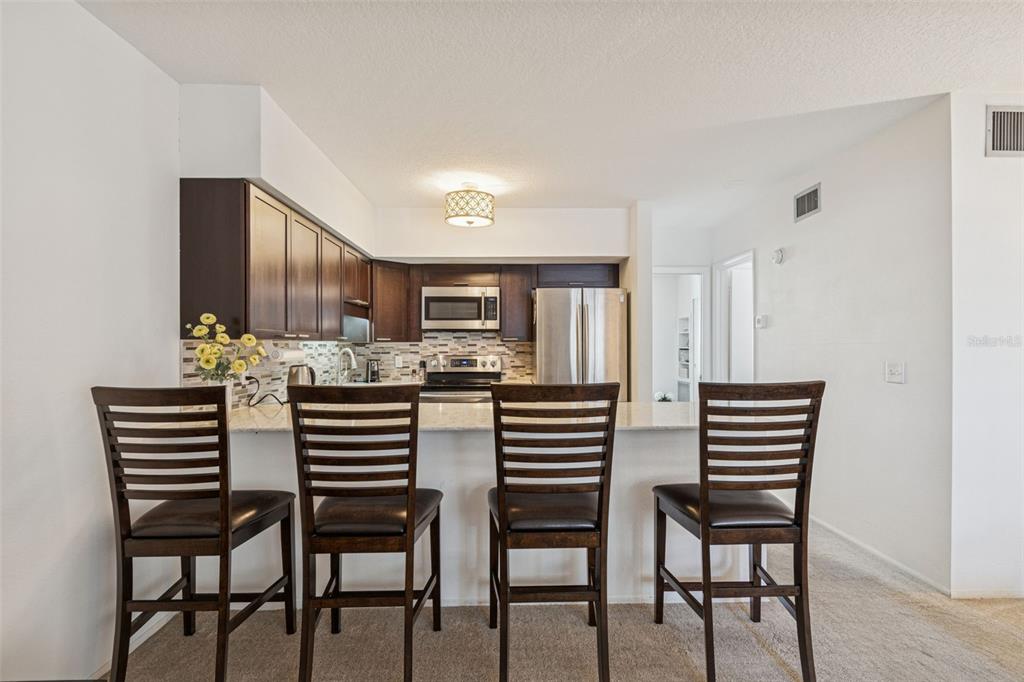 2295 Mexican Way, Unit 21 Clearwater, FL 33763 - Photo 12 of 90 a kitchen with a table chairs and white cabinets