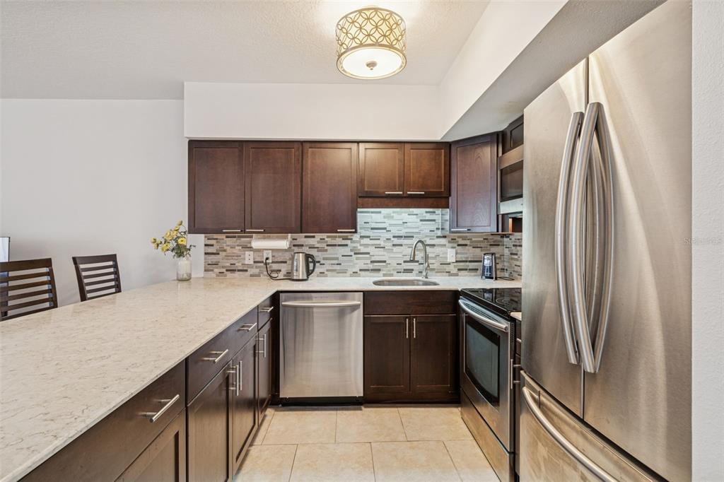 2295 Mexican Way, Unit 21 Clearwater, FL 33763 - Photo 13 of 90 a kitchen with stainless steel appliances granite countertop a sink stove and refrigerator