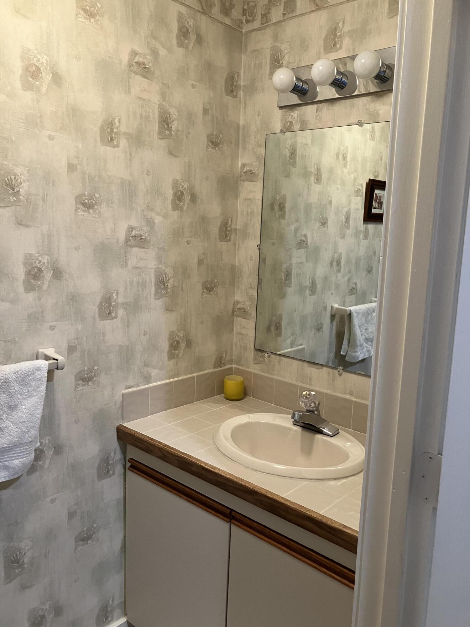 40 Shellback Way, Unit F Mashpee, MA 02649 - Photo 28 of 29 a bathroom with a sink and a mirror