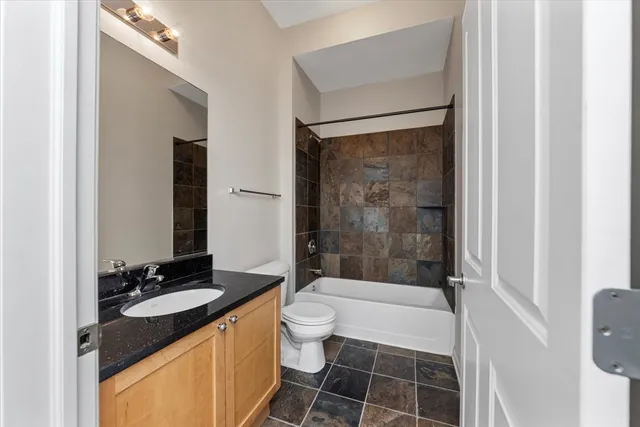 a bathroom with a granite countertop sink toilet and shower