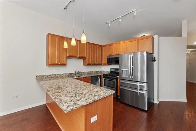 a kitchen with kitchen island a counter top space cabinets and stainless steel appliances