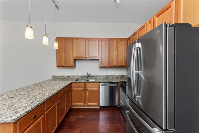 a kitchen with stainless steel appliances granite countertop a refrigerator a sink and dishwasher