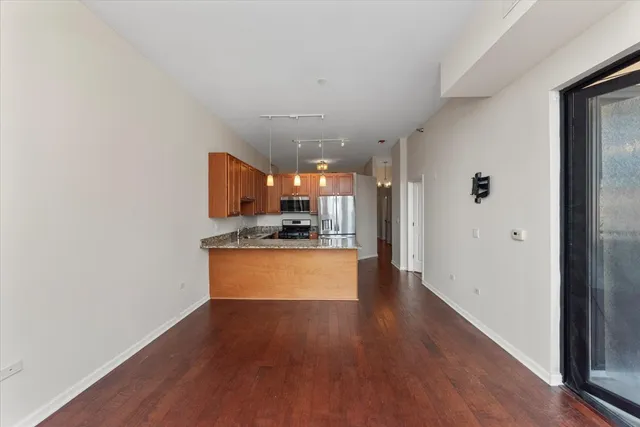 a view of a kitchen with kitchen island wooden floor center island and stainless steel appliances