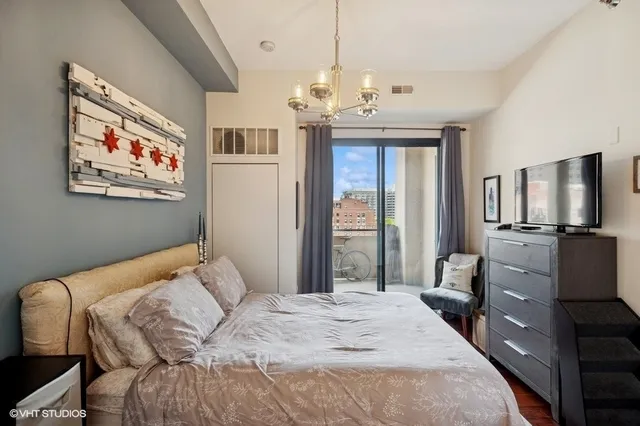 a bedroom with a large bed and a chandelier