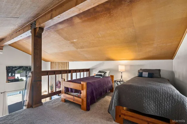 a spacious bedroom with a bed a couch and a window