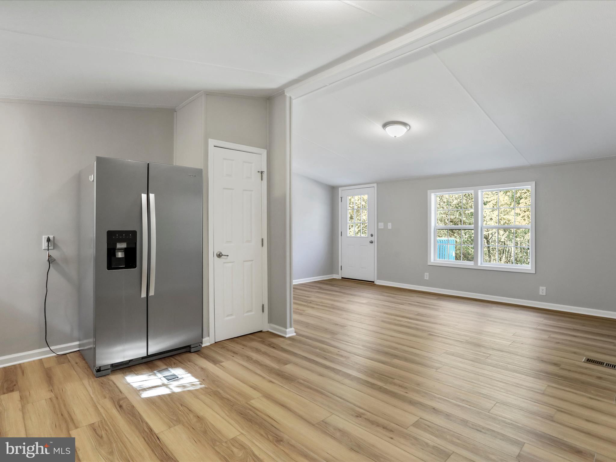 156 Potomacview Lane Berkeley Springs, WV 25411 - Photo 11 of 27 an empty room with wooden floor cabinet and windows