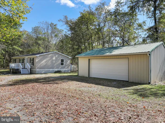 a view of a house with backyard and trees