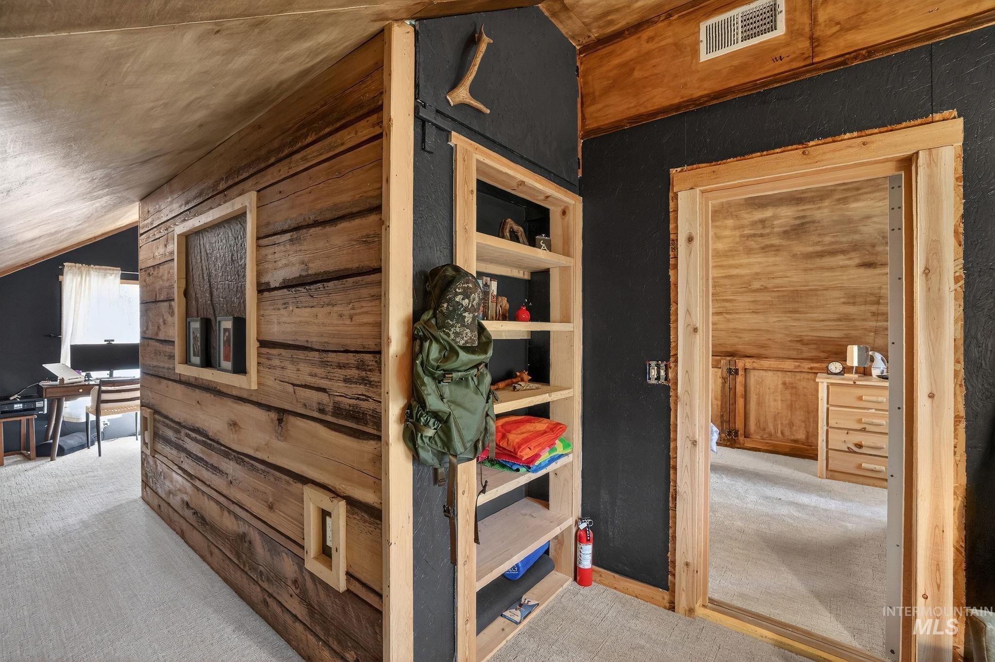 321 Secesh River Road McCall, ID 83638 - Photo 16 of 50 Interior space featuring wood paneling, wood-finish flooring, a wood-trimmed doorway, and built-in shelving