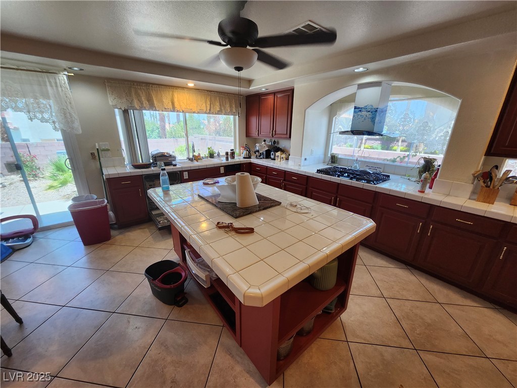 6672 Coronado Palms Avenue Las Vegas, NV 89139 - Photo 3 of 39 Kitchen featuring tile counters, wall chimney exha