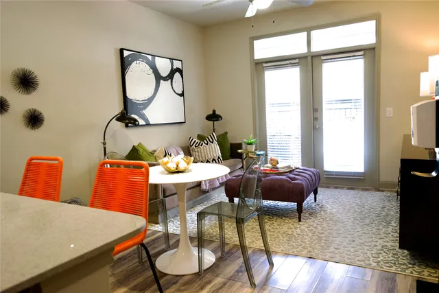 a living room with furniture a flat screen tv and a large window