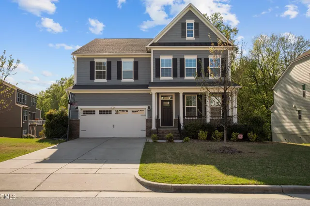 a view of a white house with large windows and a yard