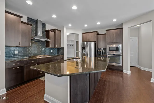 a kitchen with stainless steel appliances granite countertop a stove a sink dishwasher a refrigerator and a oven