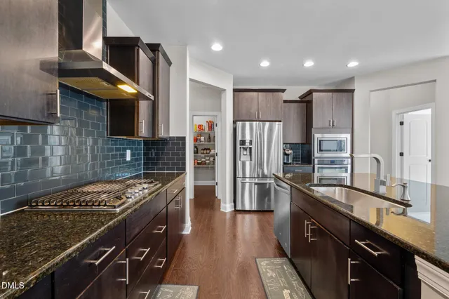 a kitchen with stainless steel appliances granite countertop a sink stove and refrigerator