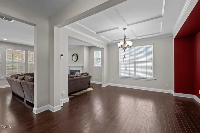 a living room with couches painting on the wall and a window