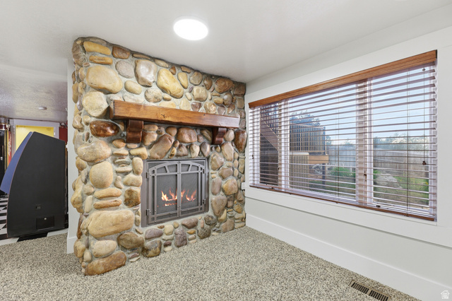 2342 Charros Road Sandy, UT 84092 - Photo 48 of 94 Stone-clad fireplace featuring a wood mantel and metal fire screen