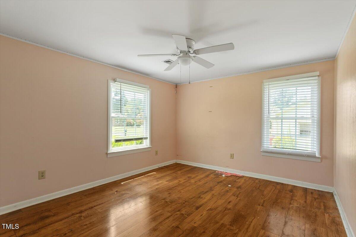 65 Pine View Road Henderson, NC 27537 - Photo 26 of 43 an empty room with wooden floor ceiling fan and windows