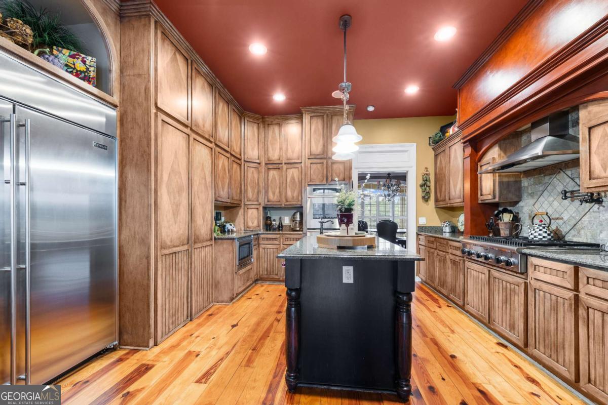 42 Claxton Road Hazlehurst, GA 31539 - Photo 39 of 73 a kitchen with stainless steel appliances granite countertop a refrigerator a sink dishwasher a stove and a dining table with wooden floor
