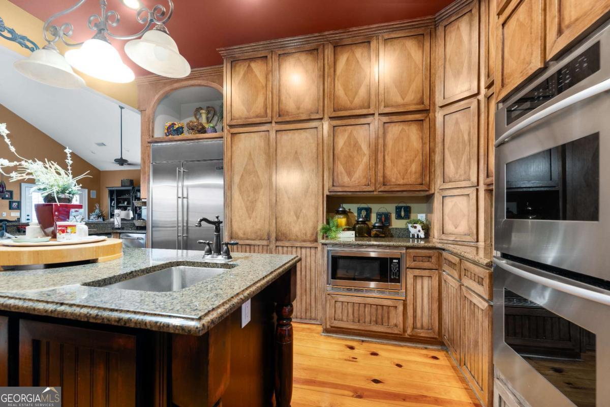 42 Claxton Road Hazlehurst, GA 31539 - Photo 40 of 73 a kitchen with stainless steel appliances granite countertop a sink a stove and a wooden floors