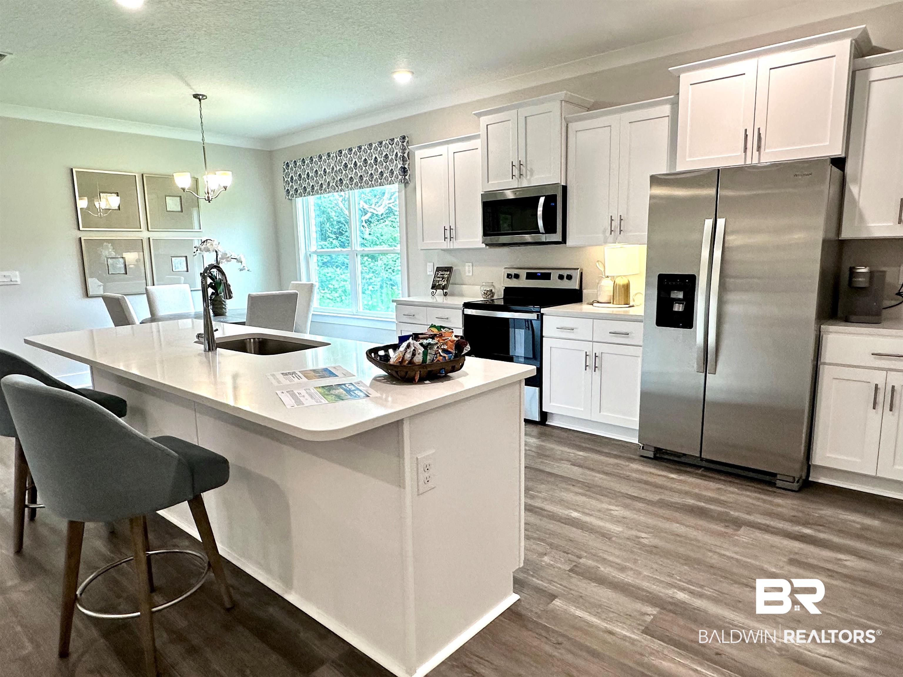 370 Barndling Street Fairhope, AL 36532 - Photo 13 of 30 Kitchen with white cabinetry, hardwood / wood-style flooring, appliances with stainless steel finishes, and sink