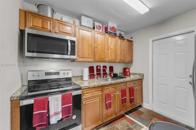a kitchen with stainless steel appliances granite countertop a stove and a microwave