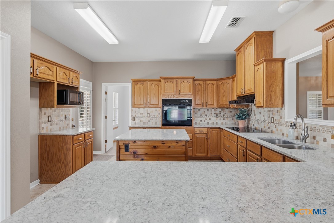 155 Guadalupe Ranch Lane Seguin, TX 78155 - Photo 25 of 48 a large kitchen with kitchen island granite countertop a sink and dishwasher a stove top oven with wooden floor