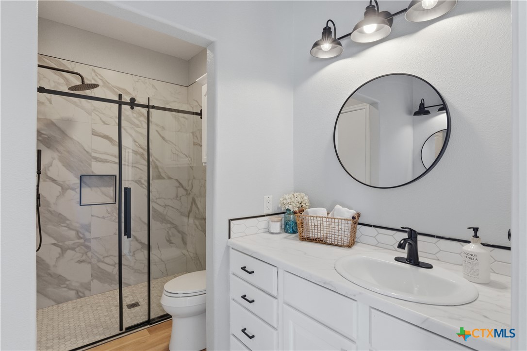 155 Guadalupe Ranch Lane Seguin, TX 78155 - Photo 33 of 48 a bathroom with a sink a toilet and a mirror